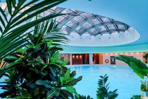 a large swimming pool in a building with plants at ANS Hanza Tower Apartment no 410 - Swimming pool and saunas not opened from 12-28 November in Szczecin