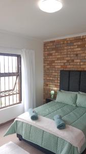 a bedroom with a bed with two towels on it at BushWave in Jeffreys Bay