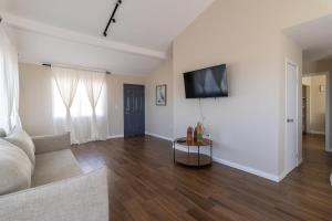 a living room with a couch and a tv on a wall at New Casa Marea #2 Beach Front House 2BR Wifi AC in Colonia Cuauhtemoc