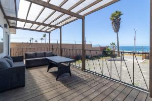 a patio with a couch and a table on a deck at New Casa Marea #2 Beach Front House 2BR Wifi AC in Colonia Cuauhtemoc +19 photos
