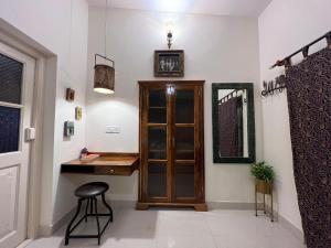 a bathroom with a wooden door and a stool at A Heritage Homestay in Jodhpur