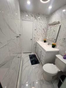 a white bathroom with a toilet and a shower at Amazing private single family house in Glendale