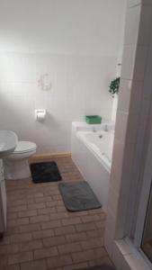 a bathroom with a tub and a toilet and a sink at BushWave in Jeffreys Bay