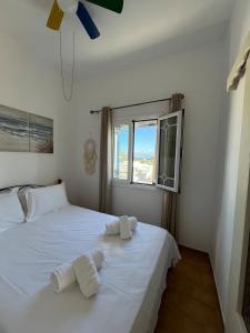 a bedroom with two beds with white sheets and a window at Cozy Corner Marmara Paros in Dhragoulás