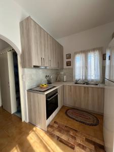 a kitchen with wooden cabinets and a stove top oven at Cozy Corner Marmara Paros in Dhragoulás