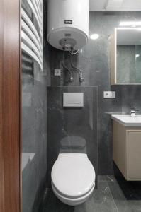 a bathroom with a white toilet and a sink at Studija-butas Markučiuose in Vilnius