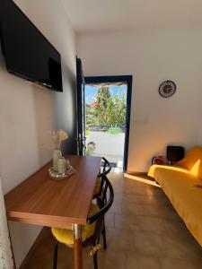 a room with a table and a bed and a tv at Cozy Corner Marmara Paros in Dhragoulás