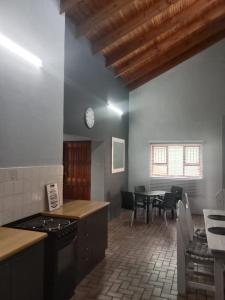 a kitchen with a table and a clock on the wall at BushWave in Jeffreys Bay
