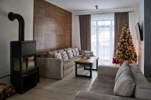 een woonkamer met een kerstboom en een bank bij Mal'ovanka in Boekovel