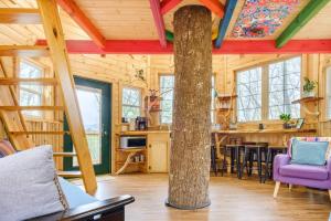 a log cabin with a tree in the middle of the room at Magical Treehouse Mountain Views Dog Friendly in Copperhill