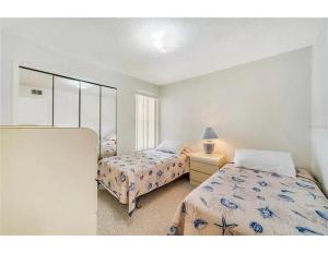 Cozy and Spacious Apartment near Disney Kissimmee في كيسيمي: غرفة نوم بها سريرين ومرآة