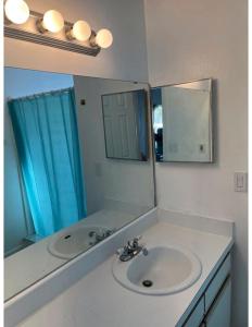 Cozy and Spacious Apartment near Disney Kissimmee في كيسيمي: حمام مع حوض ومرآة