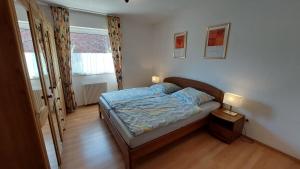 a small bedroom with a bed and two lamps at Deichkrone in Horumersiel