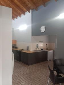 a kitchen with a sink and a clock on the wall at BushWave in Jeffreys Bay +10 photos