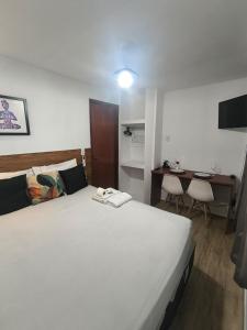 マカエにあるVaccani Apartの大きな白いベッドと机のある寝室