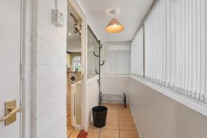 un couloir aux murs blancs, avec une fenêtre et une poubelle dans l'établissement Spacious 4 Bedroom House with Parking, à Lamesley 62 autres photos