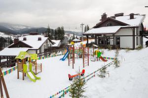 een speeltuin in de sneeuw naast een huis bij Mal'ovanka in Boekovel