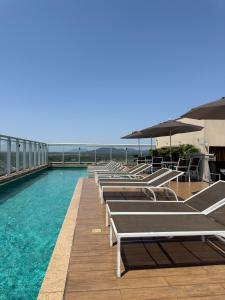 eine Reihe von Liegen auf dem Dach eines Gebäudes in der Unterkunft Promenade Fusion Itaguaí in Itaguaí