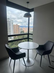a table and two chairs in a room with a window at Aparta estudio Zona Norte Bogotá in Bogotá