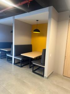 a table and chairs in a room with a yellow wall at Aparta estudio Zona Norte Bogotá in Bogotá