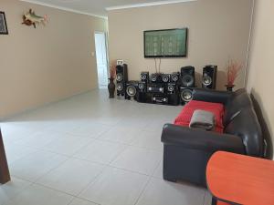 a living room with a couch and some speakers at Watergat guest house in Rehoboth