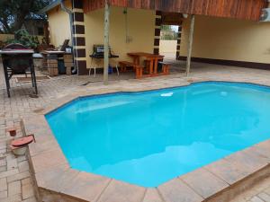 a large blue swimming pool with a patio and a table at Watergat guest house in Rehoboth