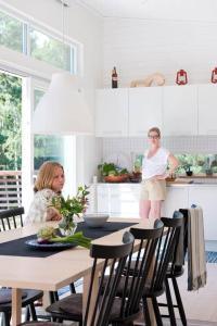 two women standing in a kitchen with a table at OGO730-Vikbolandet-Vaerldens-Aende-46 in Arkösund +2 photos