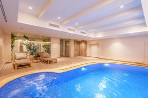 einen Innenpool in einem Haus mit Stühlen und einem Tisch in der Unterkunft Neira Boutique Hotel & Spa in Sidi Bou Saïd