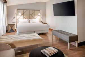 a hotel room with a bed and a tv at NH Collection León Plaza Mayor in León