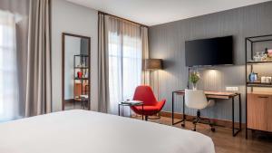 a hotel room with a bed and a desk and chairs at NH Collection León Plaza Mayor in León