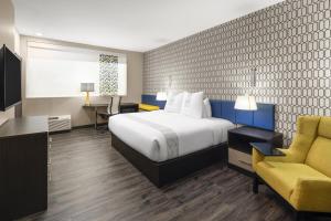 ein Hotelzimmer mit einem Bett und einem gelben Stuhl in der Unterkunft GLō Best Western Dawley Farms In Sioux Falls in Sioux Falls + 29 Fotos