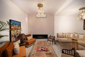 una sala de estar con un sofá y una chimenea en Riad Dar Lghizlane, en Marrakech