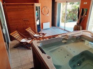a large jacuzzi tub in a room with chairs at Domaine de la Ronce in Cézac +26 photos
