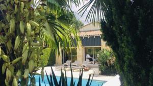 a house with a swimming pool and palm trees at Domaine de la Ronce in Cézac