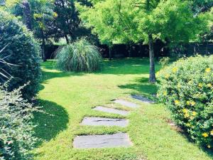un jardín con un sendero en la hierba en Le Domaine de la Ronce - Gîte & Spa, en Cézac