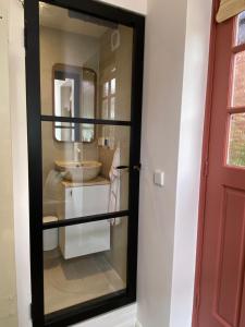 ein Badezimmer mit Spiegel und Waschbecken in der Unterkunft Cosy beach cottage in Zandvoort