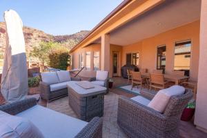 een patio met rieten meubels en een tafel en stoelen bij Upscale 4 bedroom family home near Zion w pool & hot tub in Kanab