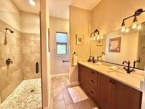 een badkamer met douche, wastafel en spiegel bij Upscale 4 bedroom family home near Zion w pool & hot tub in Kanab