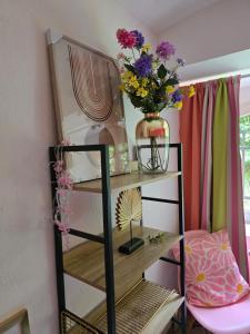 a shelf with a vase of flowers on it at Hostel Bertha-Marie Flamingo Lounge in Greifswald