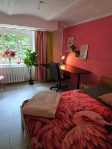 a bedroom with a bed and a desk in a room at Hostel Bertha-Marie Flamingo Lounge in Greifswald