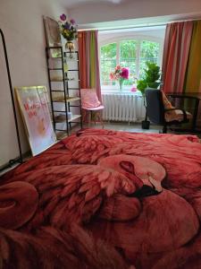 a bedroom with a large bed with a red blanket at Hostel Bertha-Marie Flamingo Lounge in Greifswald +10 photos