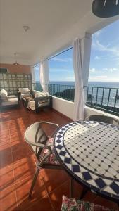 Una habitación con una mesa y sillas en un balcón. en Casa Clemente en La Bombilla, en Los Llanos de Aridane