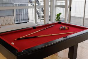 a red pool table with two cue balls on it at LUX IN THE AIR - An Elevated Experience on the Vaal Dam in Denysville