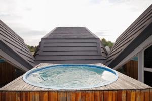 a hot tub on the deck of a house at LUX IN THE AIR - An Elevated Experience on the Vaal Dam in Denysville