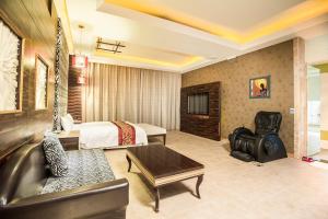 a hotel room with a bed and a couch at Moon Area Motel in Douliu