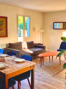 a living room with a couch and a table at Renovated house near beaches in Saint-Coulomb