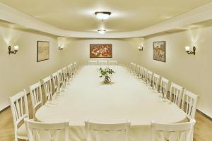 una larga mesa blanca en una habitación con sillas en Golden Hotel, en Pristina