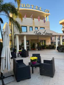 a hotel with tables and chairs in front of a building at Villa Adriana Hotel in Tivoli