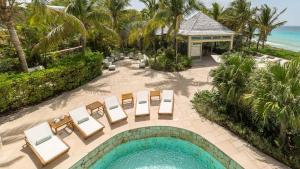 an aerial view of a pool with chairs and a house at Villa Oasis Anguilla in Long Bay Village