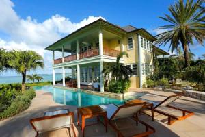a house with a swimming pool next to the ocean at Villa Oasis Anguilla in Long Bay Village +33 photos